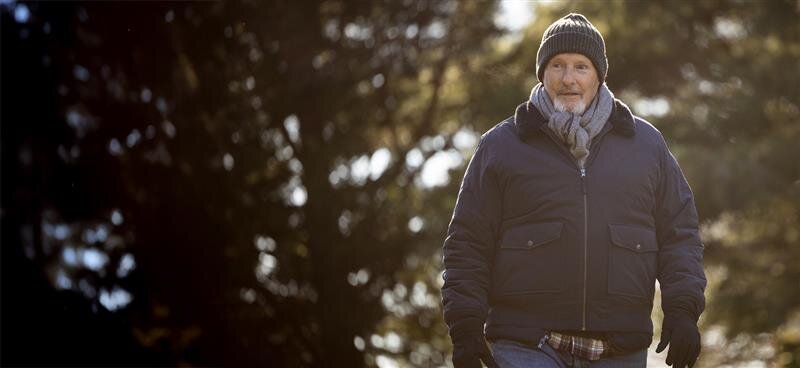 Man walking in the woods wearing winter clothes